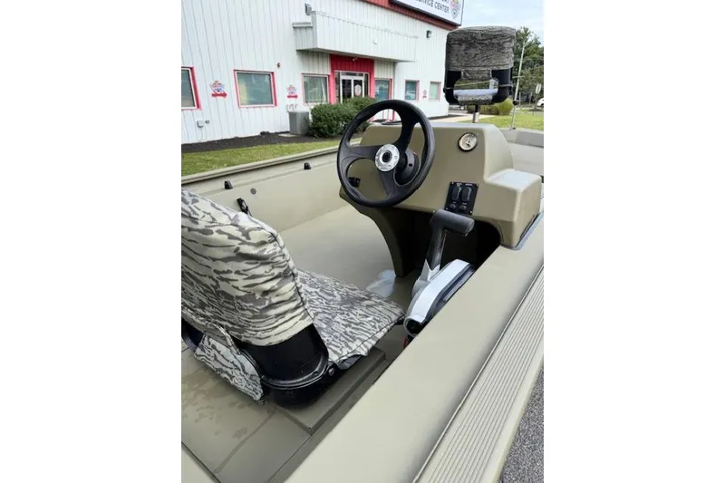 Slide: The Image of 2026 Tracker Grizzly 1754 SC boat interior with camo seats and steering wheel. - 7