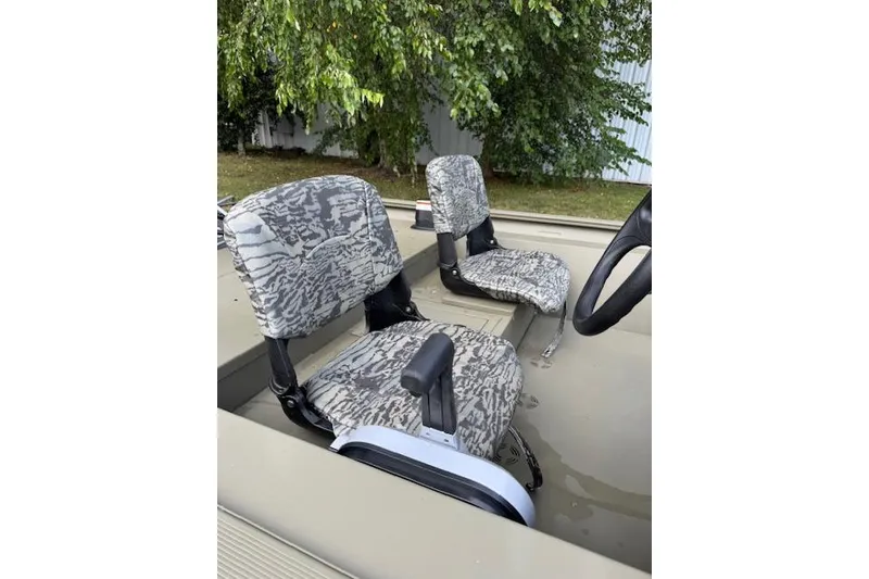 Slide: The Image of Camouflage seats in a 2026 Tracker Grizzly 1754 SC boat, surrounded by greenery. - 8