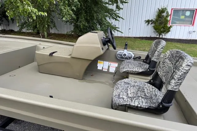 Slide: The Image of 2026 Tracker Grizzly 1754 SC boat interior with camo seats and steering console. - 9
