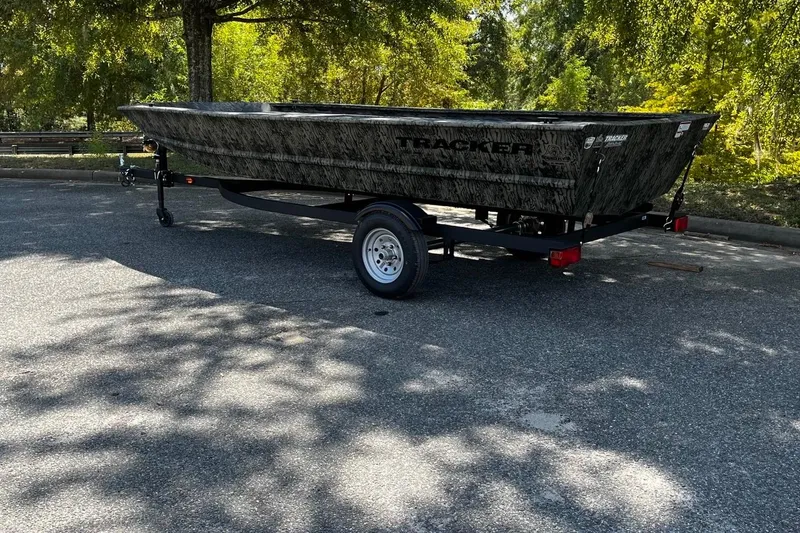 Slide: The Image of 2026 Tracker Grizzly 1648 Utility boat on trailer in a sunny parking lot. - 3