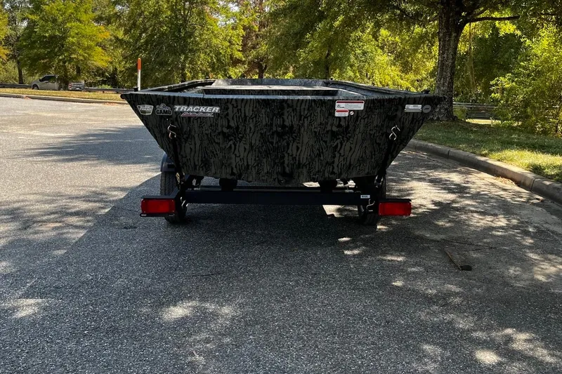 Slide: The Image of 2026 Tracker Grizzly 1648 Utility boat on trailer in a sunny park setting. - 4