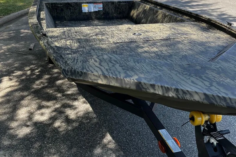 Slide: The Image of 2026 Tracker Grizzly 1648 Utility boat with camouflage design on a trailer. - 7