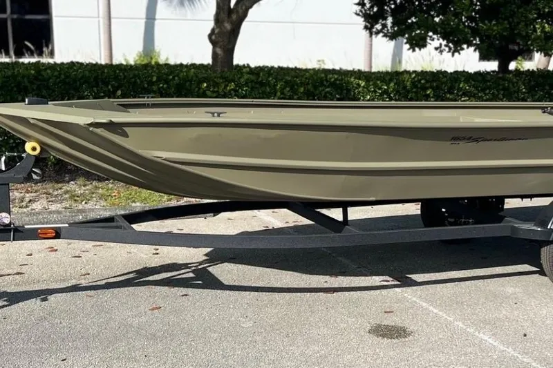 The Image of 2026 Tracker Grizzly 1654 T Sportsman boat on trailer, parked outdoors. - 0
