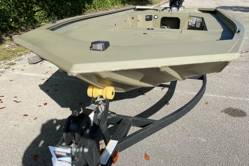 Slide: The Image of 2026 Tracker Grizzly 1654 T Sportsman boat on trailer, parked outdoors. - 11