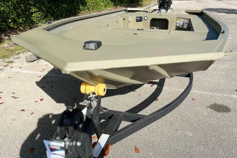 Slide: The Image of 2026 Tracker Grizzly 1654 T Sportsman boat on trailer, parked outdoors. - 2