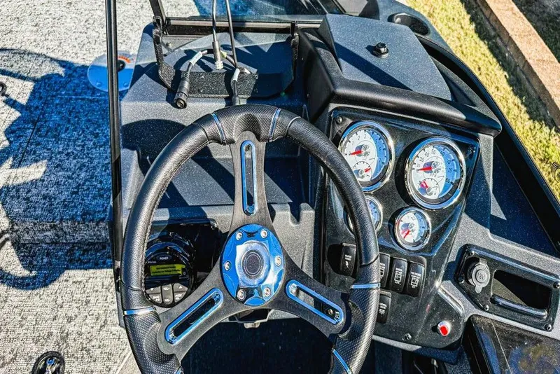 Slide: The Image of 2026 Tracker Targa V-18 Combo boat with open storage compartments and motor. - 6