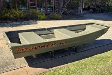 Slide: The Image of 2026 Tracker Grizzly 12 Jon boat on display outdoors. - 1