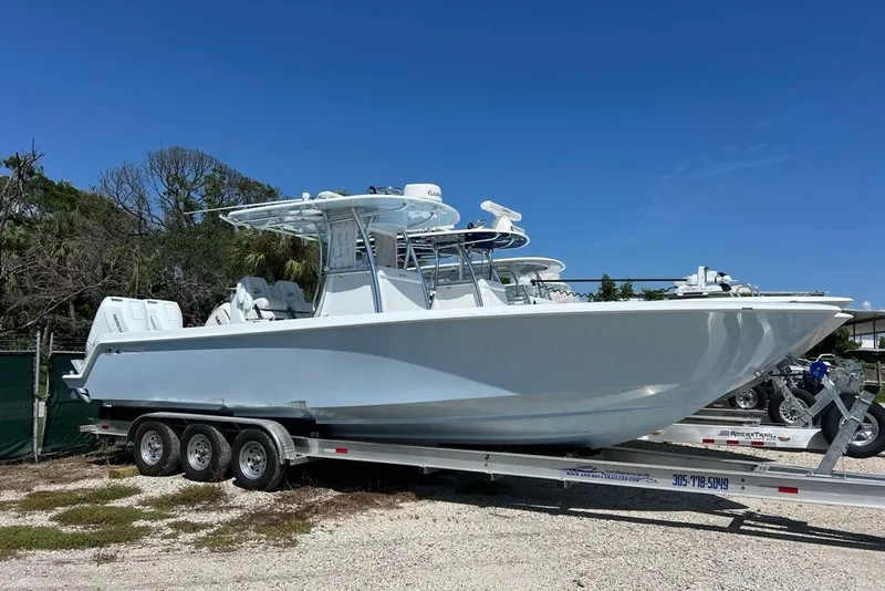 The Image of 2026 Contender 32 ST boat on trailer, parked outdoors under clear blue sky. - 1