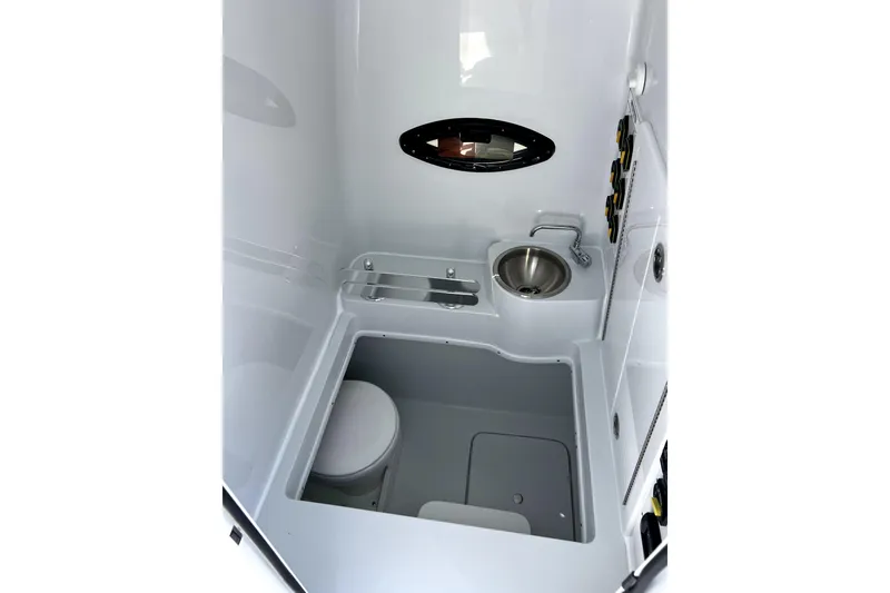 Slide: The Image of Interior of 2026 Contender 32 ST boat, featuring compact bathroom with sink and toilet. - 9