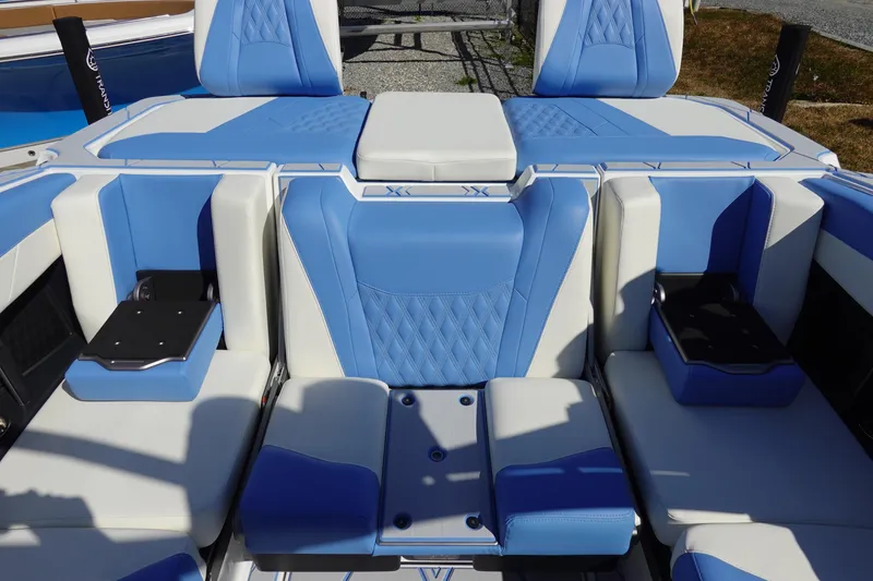 Slide: The Image of 2025 Malibu M230 boat interior with blue and white seating, featuring modern design elements. - 11