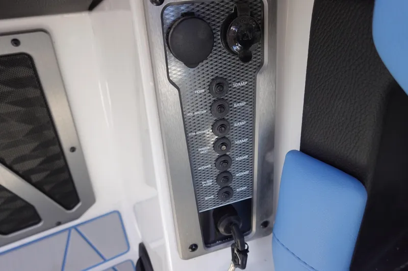 Slide: The Image of Control panel of 2025 Malibu M230 boat with switches and power outlet. - 17