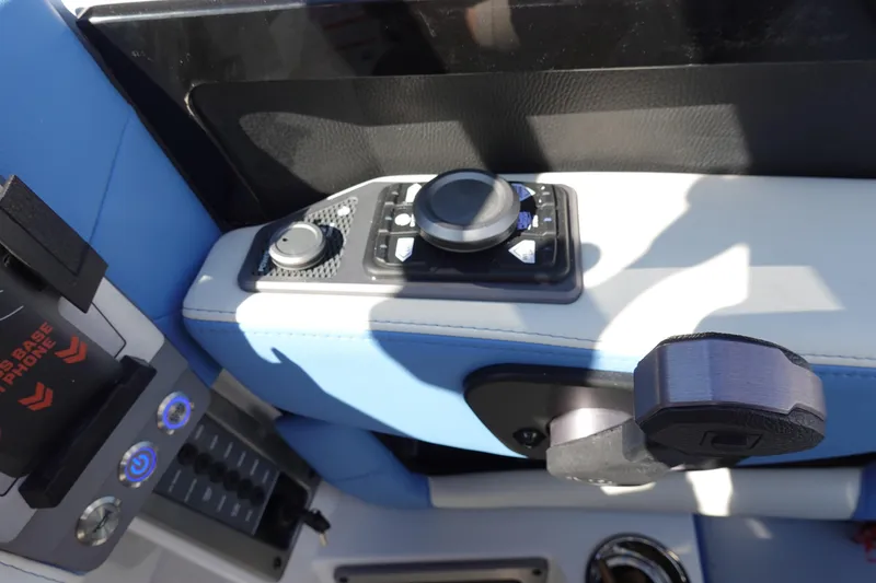 Slide: The Image of 2025 Malibu M230 boat control panel with blue and white upholstery. - 18