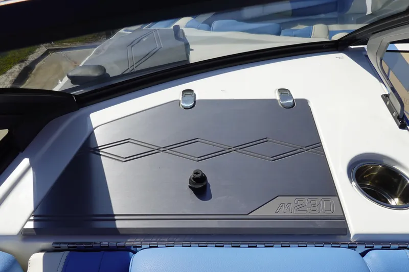 Slide: The Image of 2025 Malibu M230 boat dashboard with sleek design and cup holder. - 20