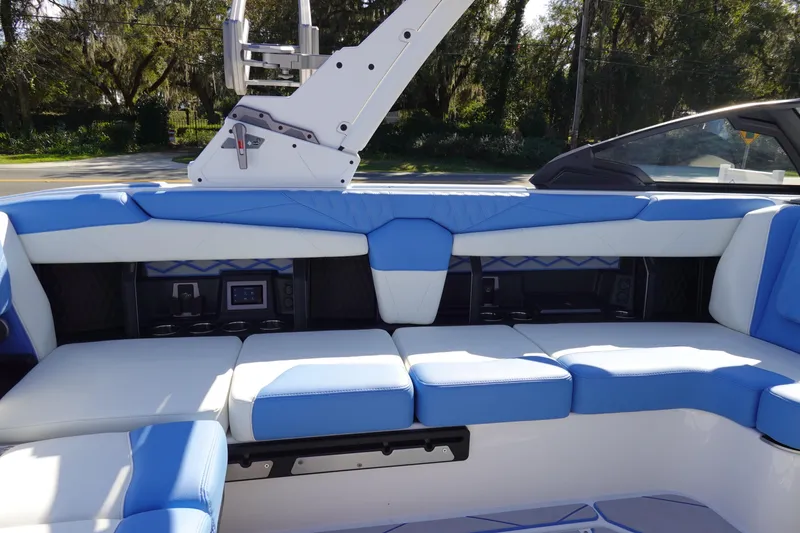 Slide: The Image of 2025 Malibu M230 boat interior with blue and white seating, featuring modern design elements. - 25