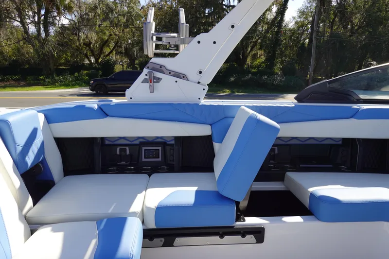 Slide: The Image of 2025 Malibu M230 boat interior with blue and white seating, featuring modern design elements. - 26