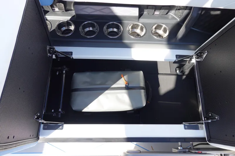 Slide: The Image of Open storage compartment in 2025 Malibu M230 boat with cup holders and bag. - 29