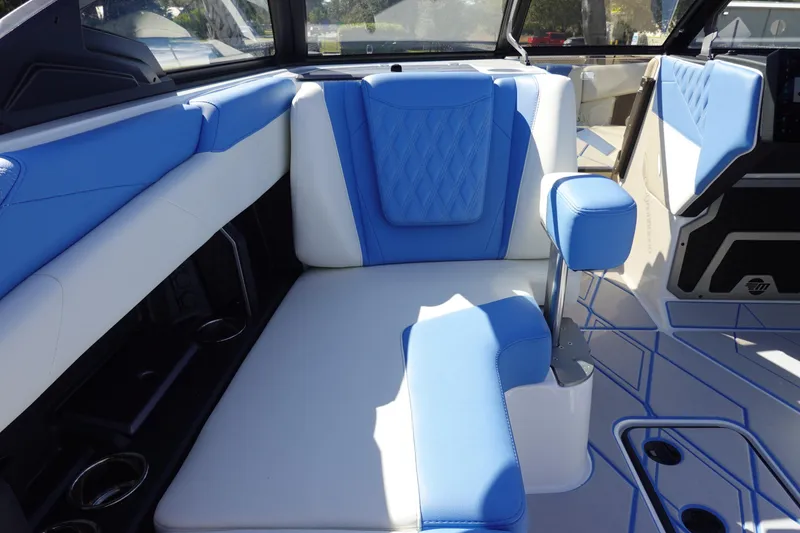 Slide: The Image of 2025 Malibu M230 boat interior with blue and white seating, showcasing modern design. - 33