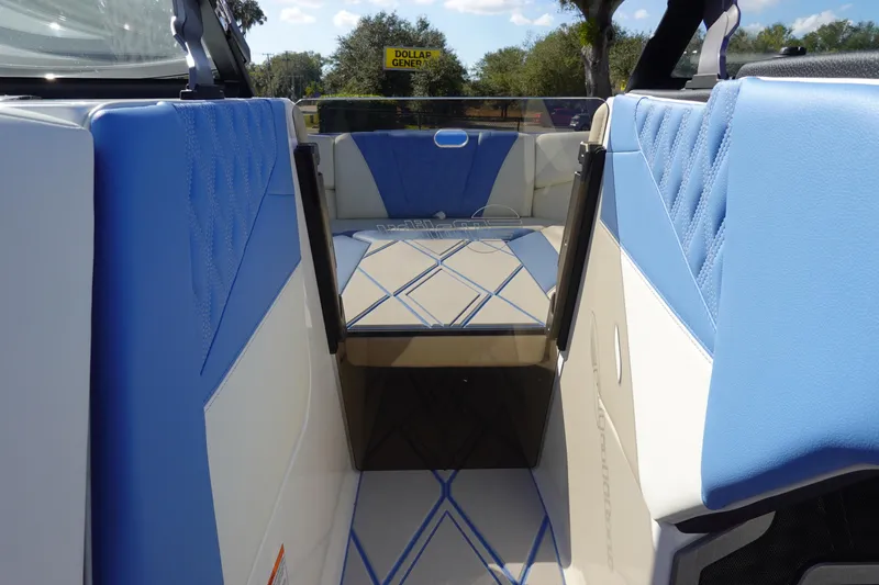 Slide: The Image of 2025 Malibu M230 boat interior with blue and white seating, outdoor view. - 34