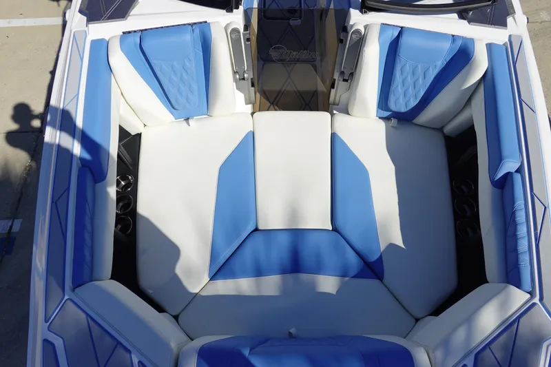 Slide: The Image of 2025 Malibu M230 boat interior with blue and white seating, showcasing luxury design. - 36