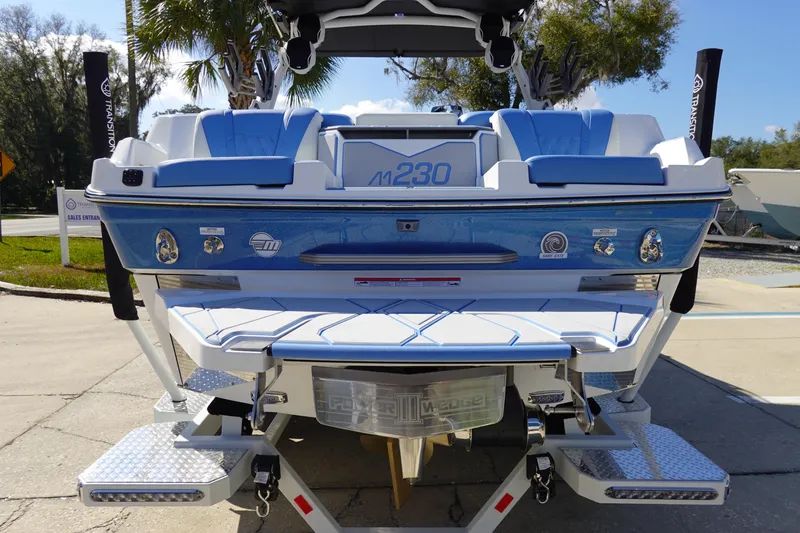 Slide: The Image of 2025 Malibu M230 boat, rear view, featuring blue and white design with modern features. - 5