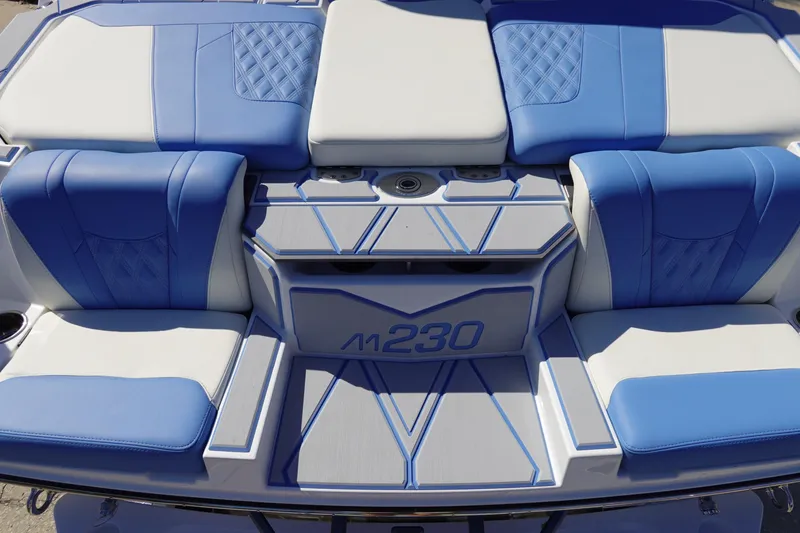 Slide: The Image of 2025 Malibu M230 boat interior with blue and white seating, showcasing modern design. - 8