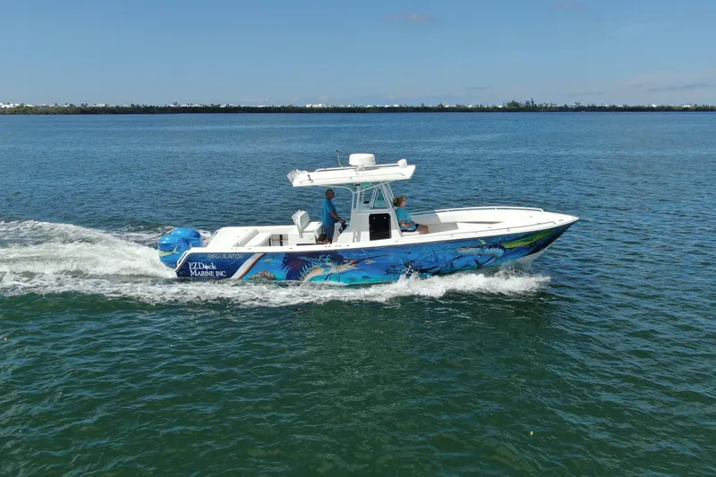 Slide: The Image of 2001 Regulator 32 Center Console boat cruising on open water with vibrant marine graphics. - 10