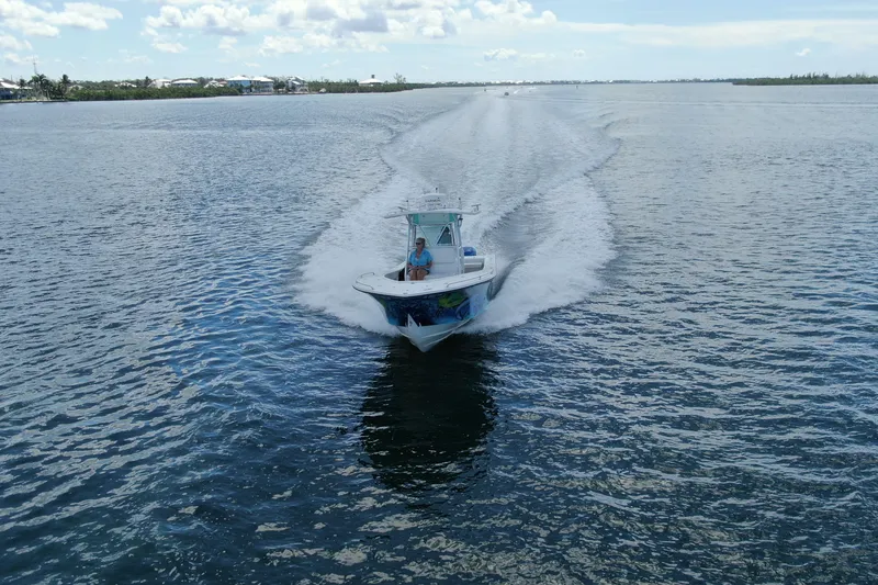 Slide: The Image of 2001 Regulator 32 Center Console boat cruising on open water under a clear sky. - 18