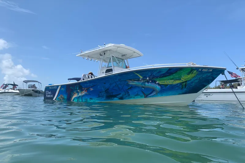 Slide: The Image of 2001 Regulator 32 Center Console boat with vibrant marine-themed hull design on the water. - 2