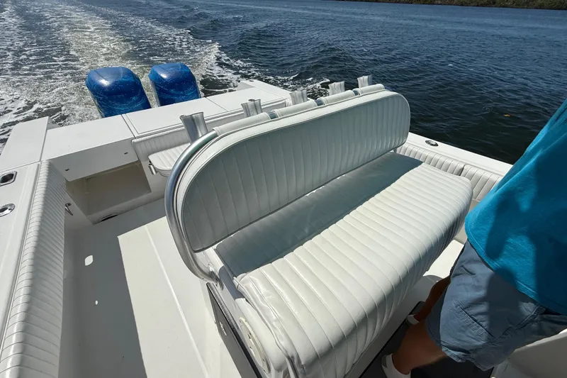 Slide: The Image of 2001 Regulator 32 Center Console boat with white seating and dual outboard motors on water. - 22