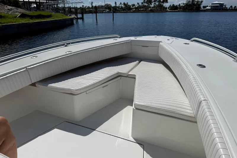 Slide: The Image of 2001 Regulator 32 Center Console boat with white seating, docked by calm water. - 38