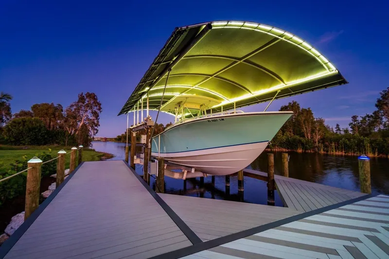 Slide: The Image of 2001 Regulator 32 Center Console boat docked under illuminated canopy at sunset. - 4
