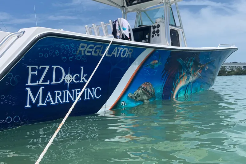 Slide: The Image of 2001 Regulator 32 Center Console boat with vibrant marine-themed graphics on water. - 5