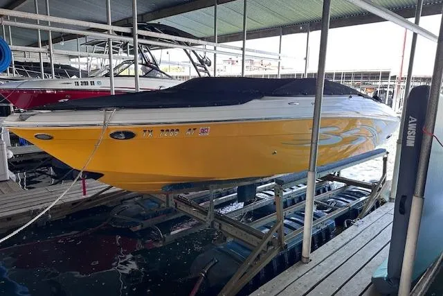 The Image of 2004 Four Winns 210 Horizon SS boat in dock, vibrant yellow hull, covered, side view. - 0