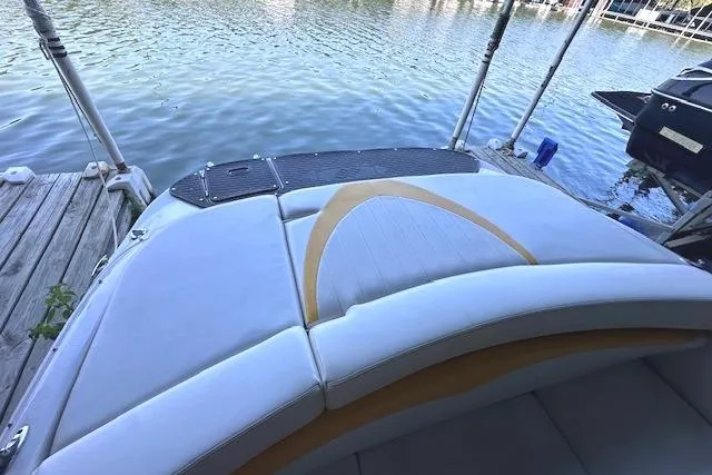 Slide: The Image of 2004 Four Winns 210 Horizon SS boat with cushioned seating, docked by the water. - 13