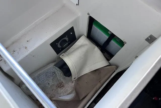 Slide: The Image of Storage compartment in a 2004 Four Winns 210 Horizon SS boat, featuring various items. - 18