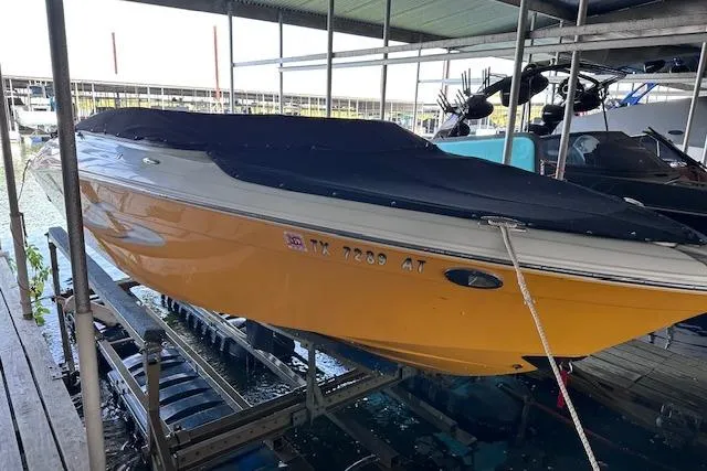 Slide: The Image of 2004 Four Winns 210 Horizon SS boat with black cover, docked in a marina. - 20