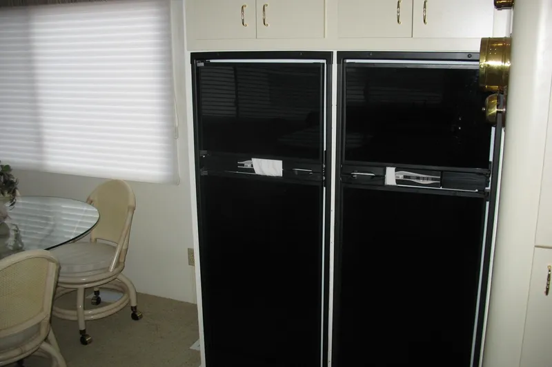 Slide: The Image of Interior of 1993 Skipper Liner houseboat with dining area and black appliances. - 13
