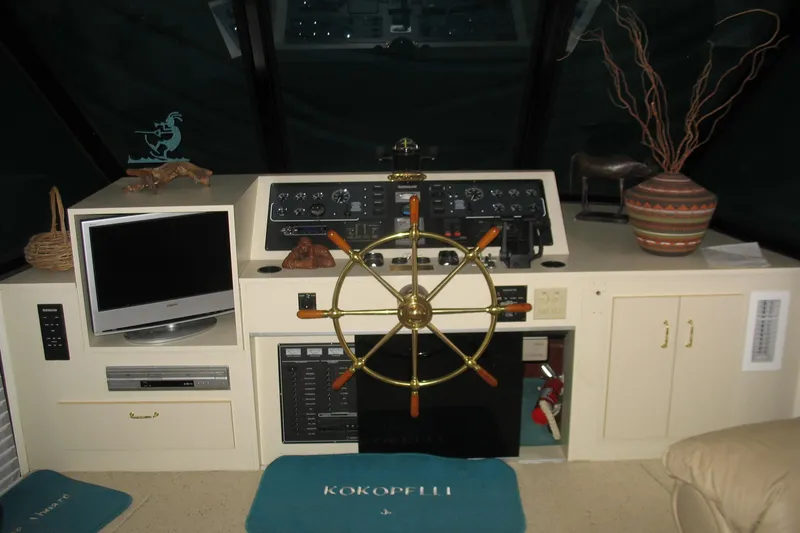 Slide: The Image of 1993 Skipper Liner houseboat helm with steering wheel, control panel, and TV setup. - 17