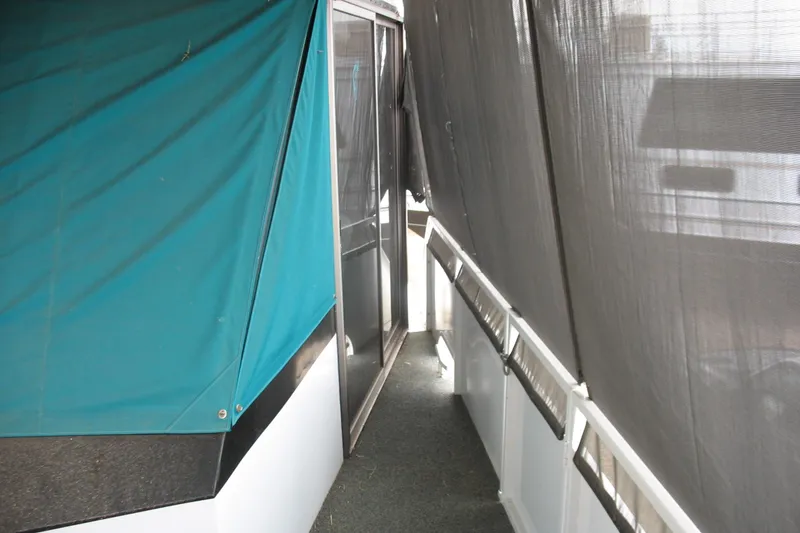 Slide: The Image of 1993 Skipper Liner houseboat with teal and black exterior canopy. - 19
