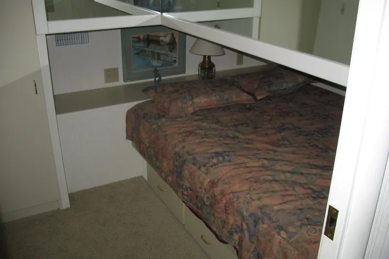 Slide: The Image of Cozy bedroom interior of a 1993 Skipper Liner houseboat with patterned bedding. - 21