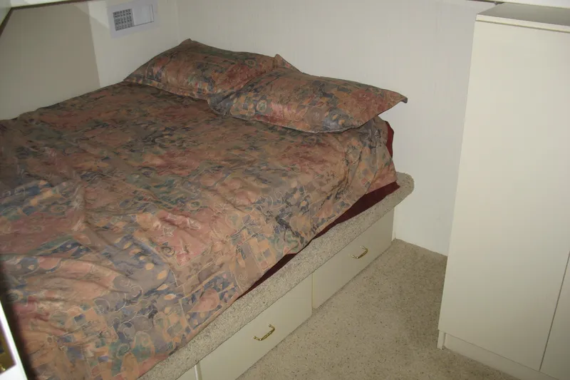 Slide: The Image of Cozy bedroom in 1993 Skipper Liner houseboat with patterned bedding and storage drawers. - 22