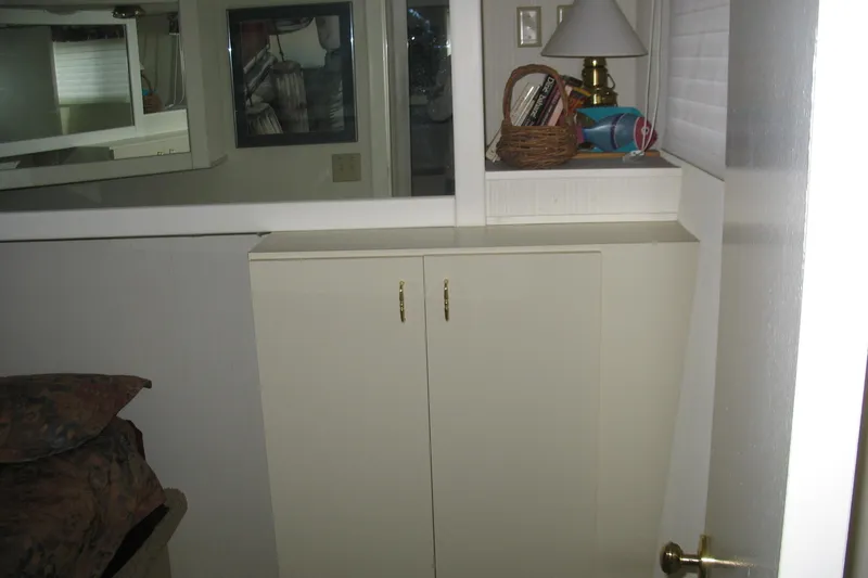 Slide: The Image of Interior of 1993 Skipper Liner houseboat with cabinet, lamp, and decorative items. - 23