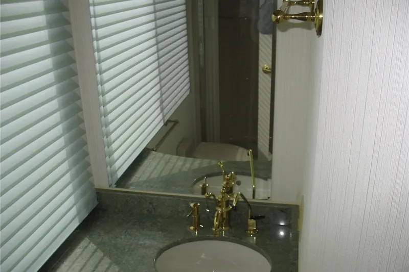 Slide: The Image of Bathroom interior of 1993 Skipper Liner houseboat with gold fixtures and blinds. - 32
