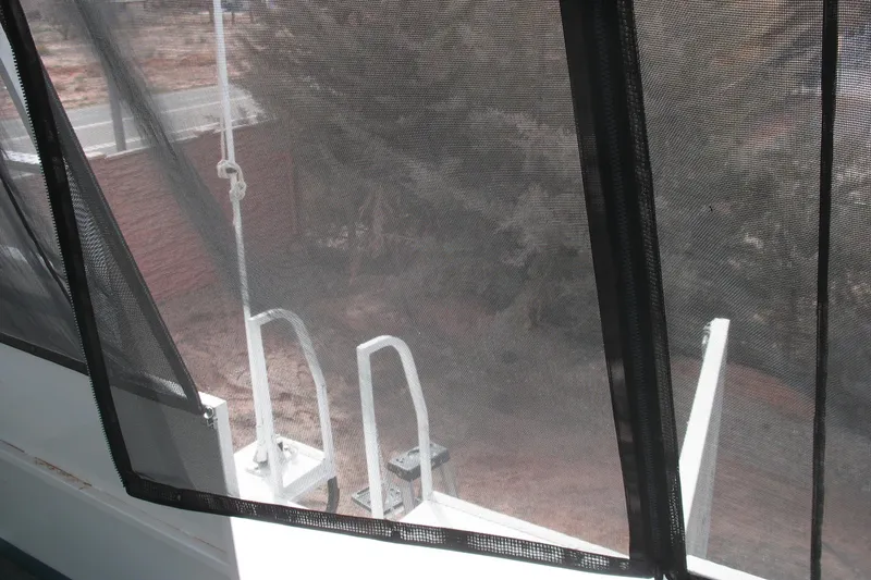 Slide: The Image of View from 1993 Skipper Liner houseboat, showing mesh screen and outdoor scenery. - 36