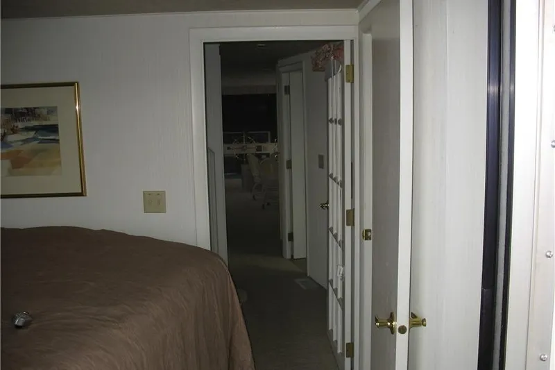 Slide: The Image of Interior of a 1993 Skipper Liner houseboat, featuring a hallway and bedroom. - 38