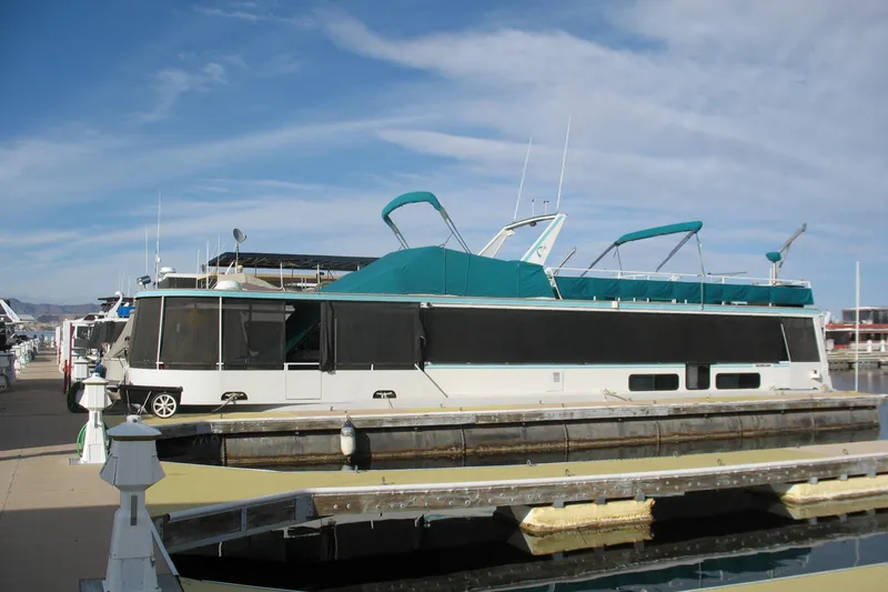 Slide: The Image of 1993 Skipper Liner houseboat docked at marina under clear blue sky. - 4