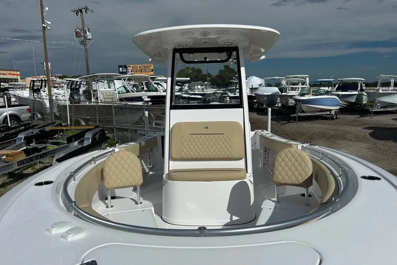 Slide: The Image of 2026 Sportsman Open 232 Center Console boat with beige seating, displayed outdoors. - 12