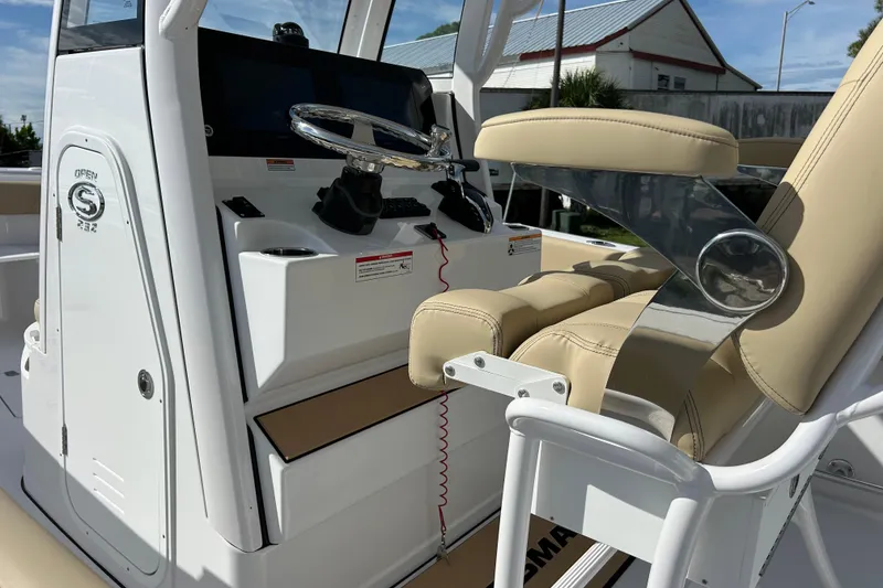 Slide: The Image of 2026 Sportsman Open 232 Center Console boat interior with steering wheel and beige seating. - 13