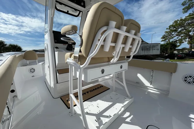 Slide: The Image of 2026 Sportsman Open 232 Center Console boat interior with beige seating and rod holders. - 15