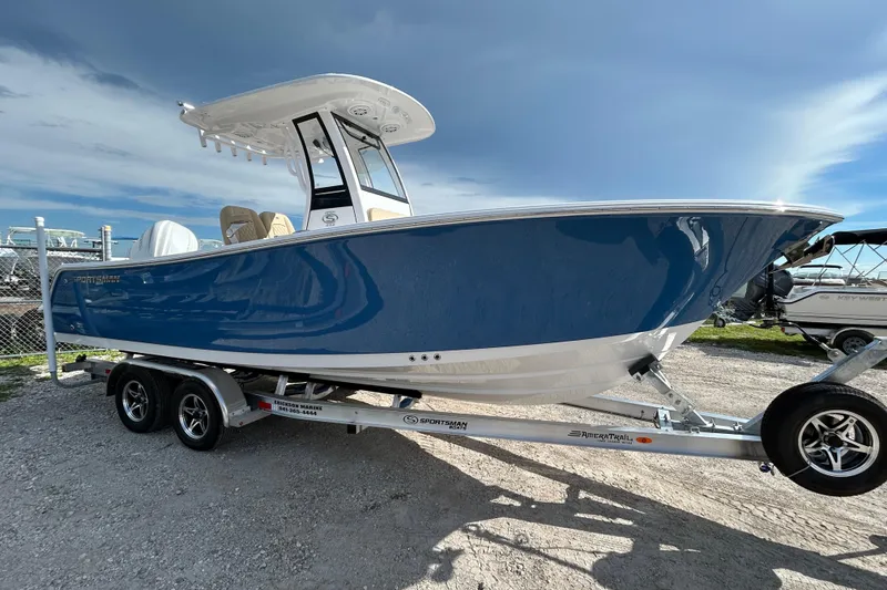 Slide: The Image of 2026 Sportsman Open 232 Center Console boat on trailer, blue hull, parked outdoors. - 3